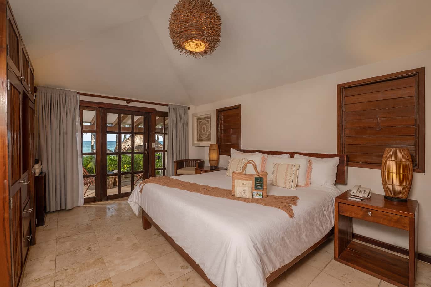 Ana y Jose hotel room, wooden bed, balcony with sea view, warm décor
